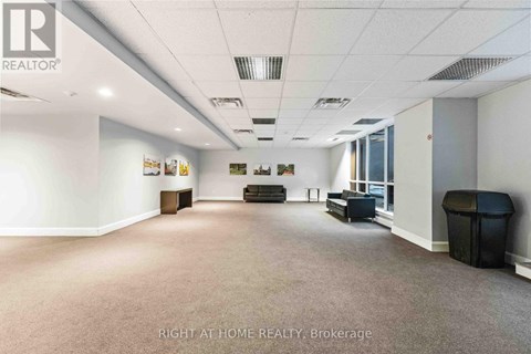 A spacious office room with a carpeted floor and white walls.