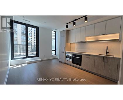 A well-lit, modern kitchen with wooden cabinets and stainless steel appliances.