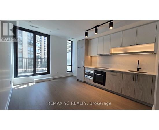 A well-lit, modern kitchen with wooden cabinets and stainless steel appliances.