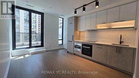 A well-lit, modern kitchen with wooden cabinets and stainless steel appliances.