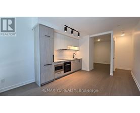 A brokerage sign is on the wall of a small, empty room.
