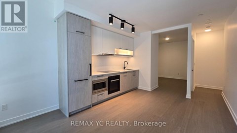 A brokerage sign is on the wall of a small, empty room.
