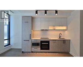 A kitchen with a sink, oven, and cabinets.