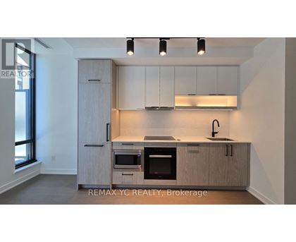 A kitchen with a sink, oven, and cabinets.