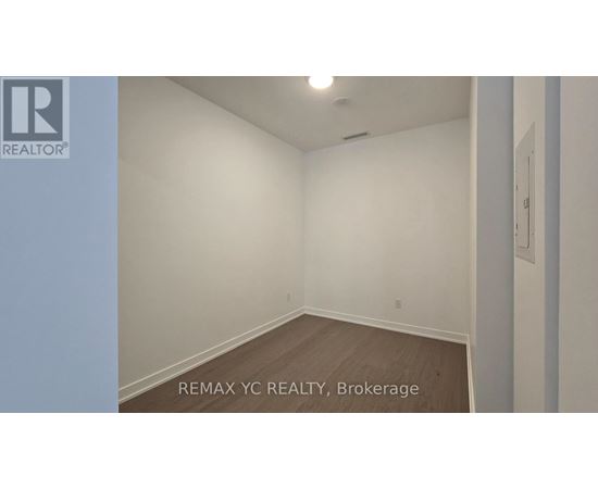 A room with a white wall and a wooden floor.