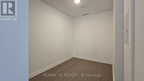 A room with a white wall and a wooden floor.