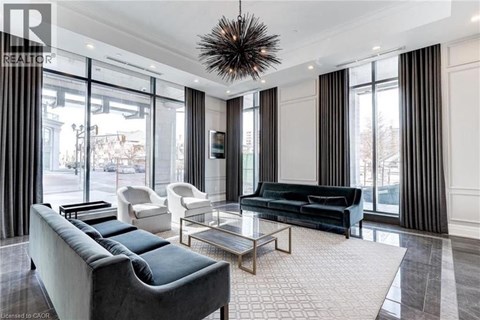 A living room with a large couch and a glass table.