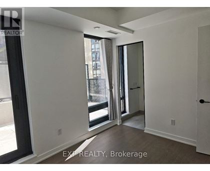 A room with a sliding glass door leading to a balcony.