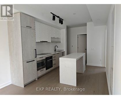 A kitchen with wooden cabinets and a marble island.