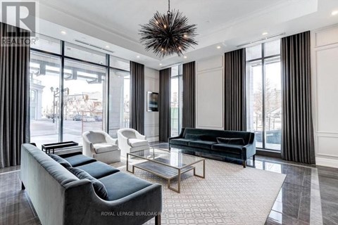 A living room with a black sofa and a glass table.