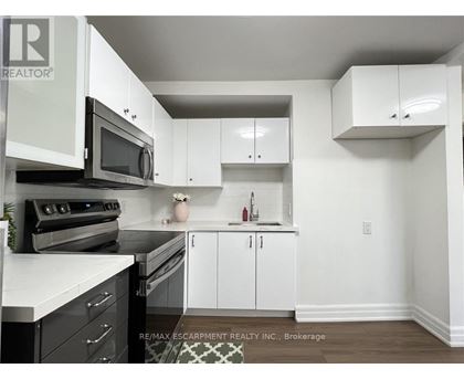 A kitchen with white cabinets and black appliances.