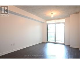 A spacious room with a sliding glass door leading to a balcony.