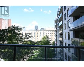 A balcony overlooks a cityscape with buildings and trees.
