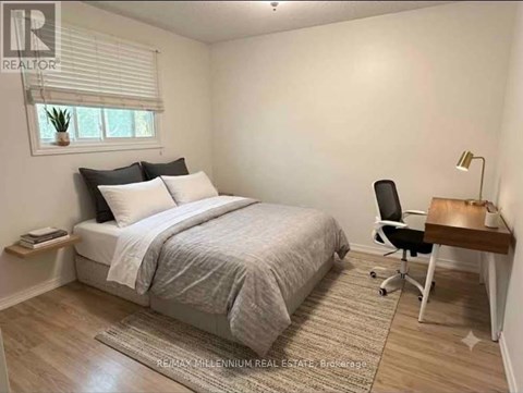 A bedroom with a bed, chair, and desk.