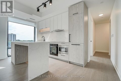 A modern kitchen with white cabinets and a marble island.