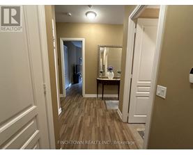 A hallway with a mirror and a table with flowers on it.
