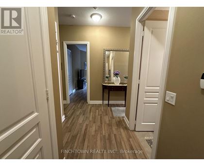 A hallway with a mirror and a table with flowers on it.