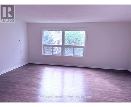 A room with a large window and wooden flooring.