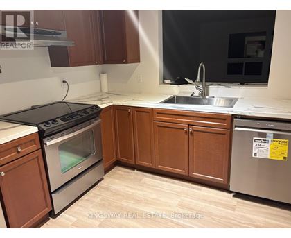 A kitchen with wooden cabinets and a stainless steel dishwasher.