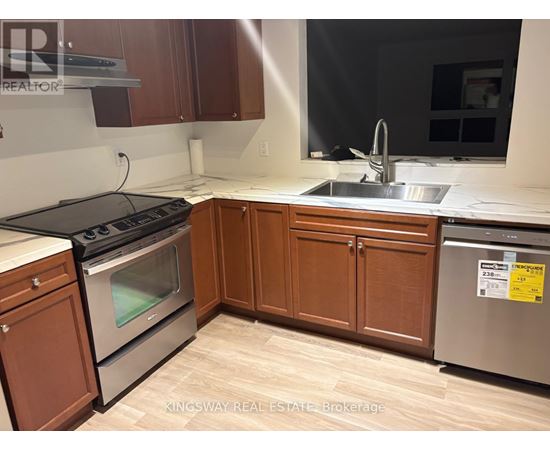 A kitchen with wooden cabinets and a stainless steel dishwasher.