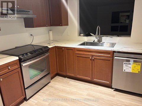 A kitchen with wooden cabinets and a stainless steel dishwasher.