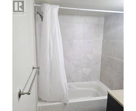A white shower curtain hangs over a bathtub in a bathroom.