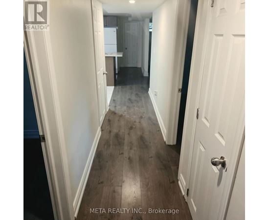 A hallway with white doors and a wooden floor.