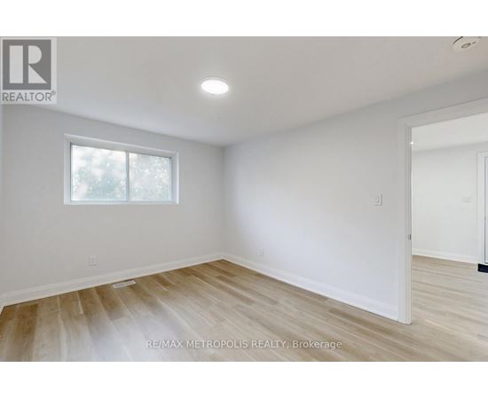 A room with a window and wooden flooring.