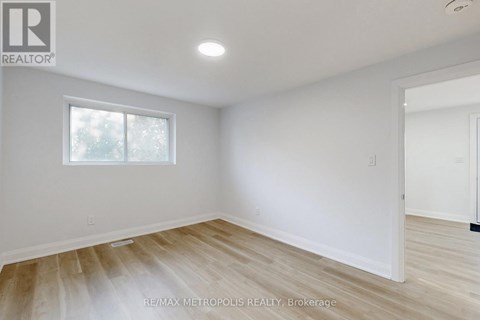 A room with a window and wooden flooring.