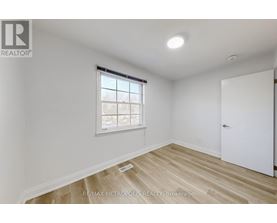 A room with a window and wooden flooring.