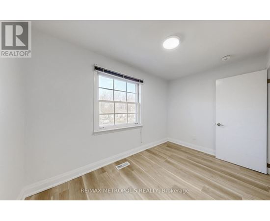 A room with a window and wooden flooring.
