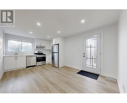 A spacious kitchen with white cabinets and stainless steel appliances.