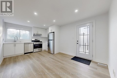 A spacious kitchen with white cabinets and stainless steel appliances.
