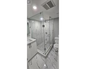 A bathroom with a marble floor and a walk-in shower.