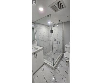 A bathroom with a marble floor and a walk-in shower.