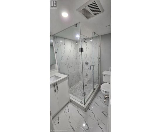 A bathroom with a marble floor and a walk-in shower.