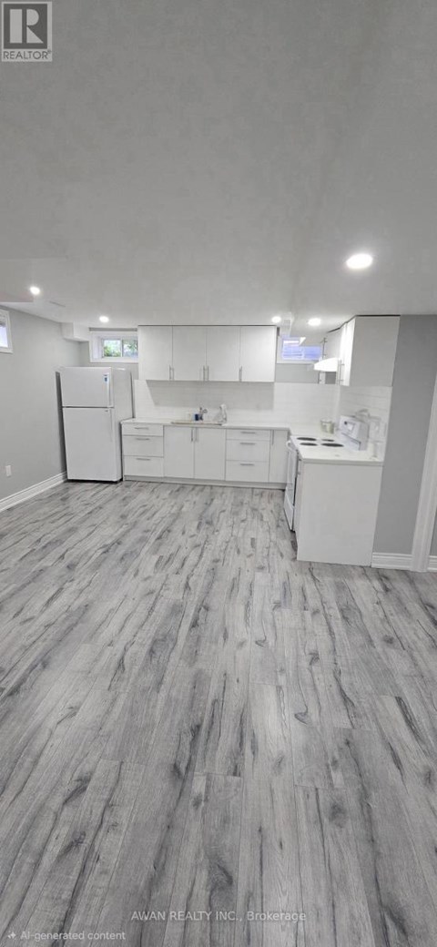 A spacious kitchen with white cabinets and a refrigerator.