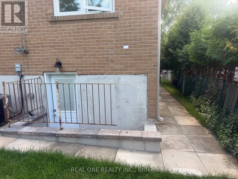A brick building with a white door and a metal gate.