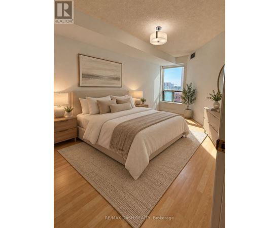 A bedroom with a large bed and a painting on the wall.