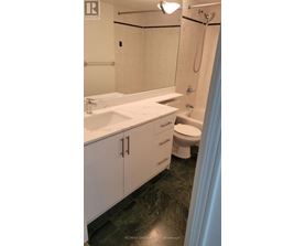 A bathroom with a sink, toilet, and shower.