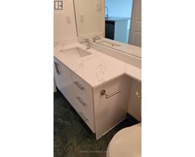 A bathroom with a sink, mirror, and toilet.