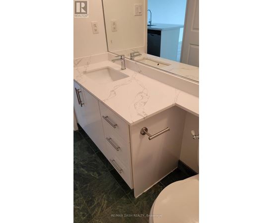 A bathroom with a sink, mirror, and toilet.