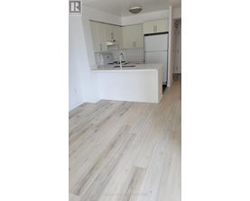 A kitchen with white cabinets and a white island with a sink.