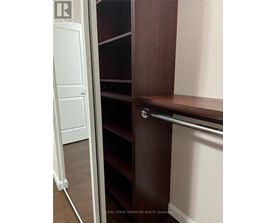 A white door is open to a room with a brown shelf.