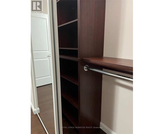 A white door is open to a room with a brown shelf.