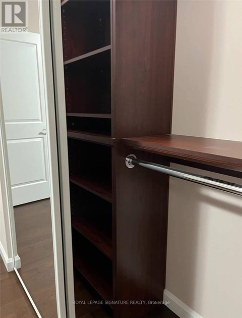 A white door is open to a room with a brown shelf.
