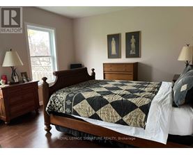 A bedroom with a bed, nightstand, and lamp.
