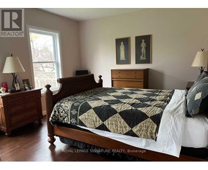 A bedroom with a bed, nightstand, and lamp.