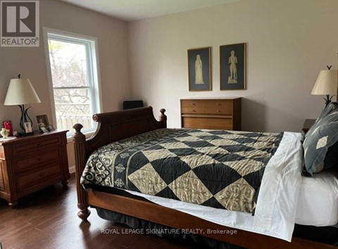 A bedroom with a bed, nightstand, and lamp.