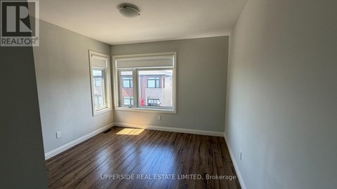 A room with a window and wooden flooring.